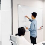 Person presenterar en kurva på whiteboard inför en kollega