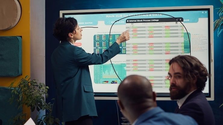 Kollegor granskar digitala process- och lagerdata på en stor skärm